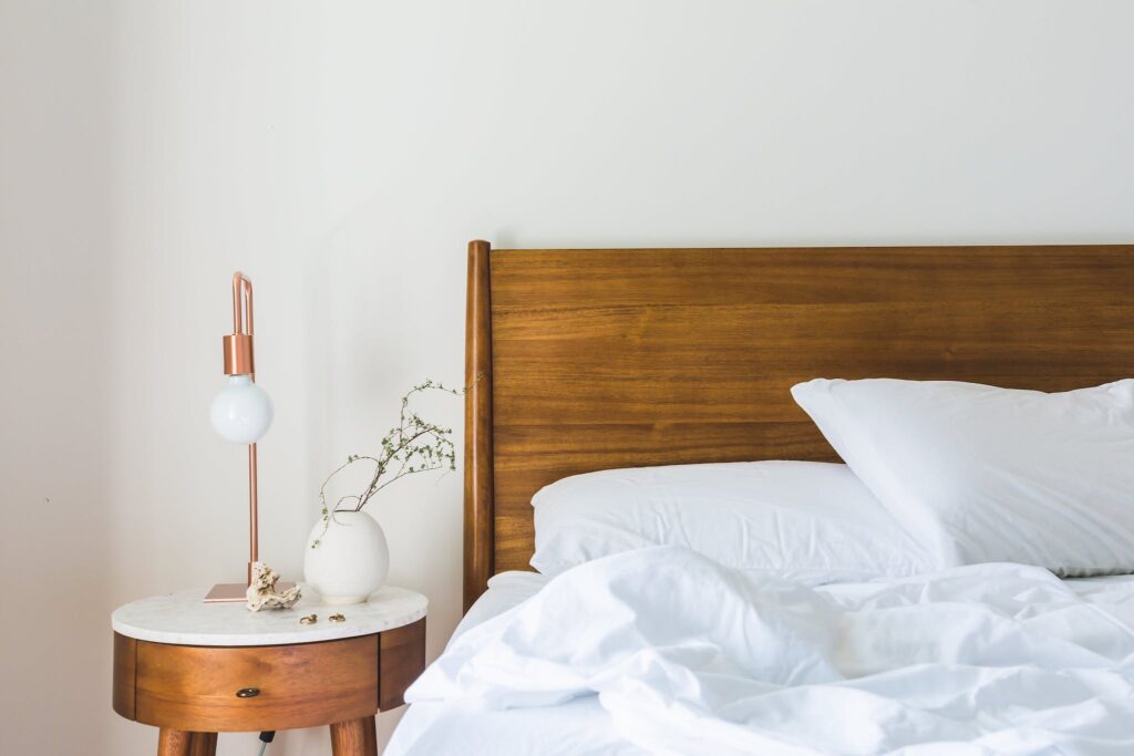 White Bedspread Beside Nightstand With White and Copper Table Lamp - steam cleaner for mattress